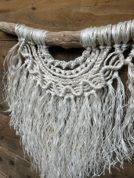 Detail of costal rope wall art highlighting layered knots and weathered texture, in soft white, set on driftwood