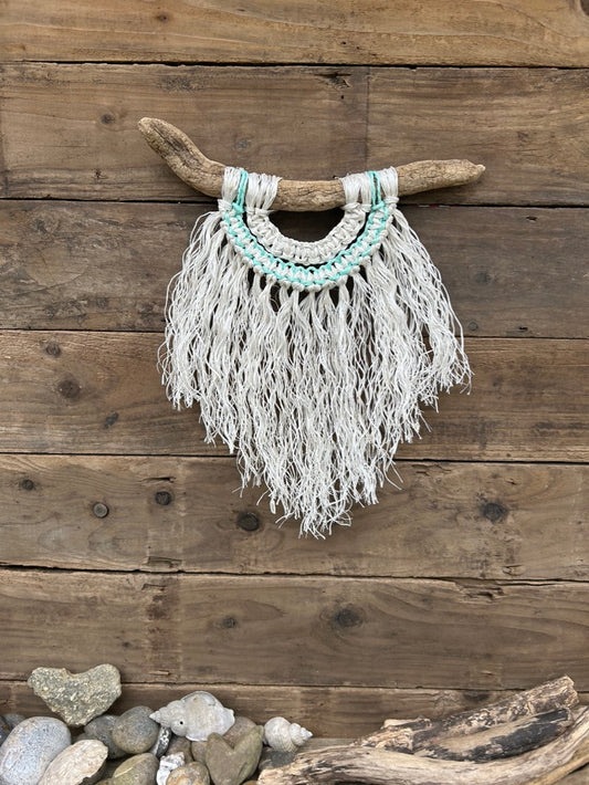 Handcrafted, repurposed fishing rope coastal wall hanging, with a weathered white fringe and soft green current flowing through.