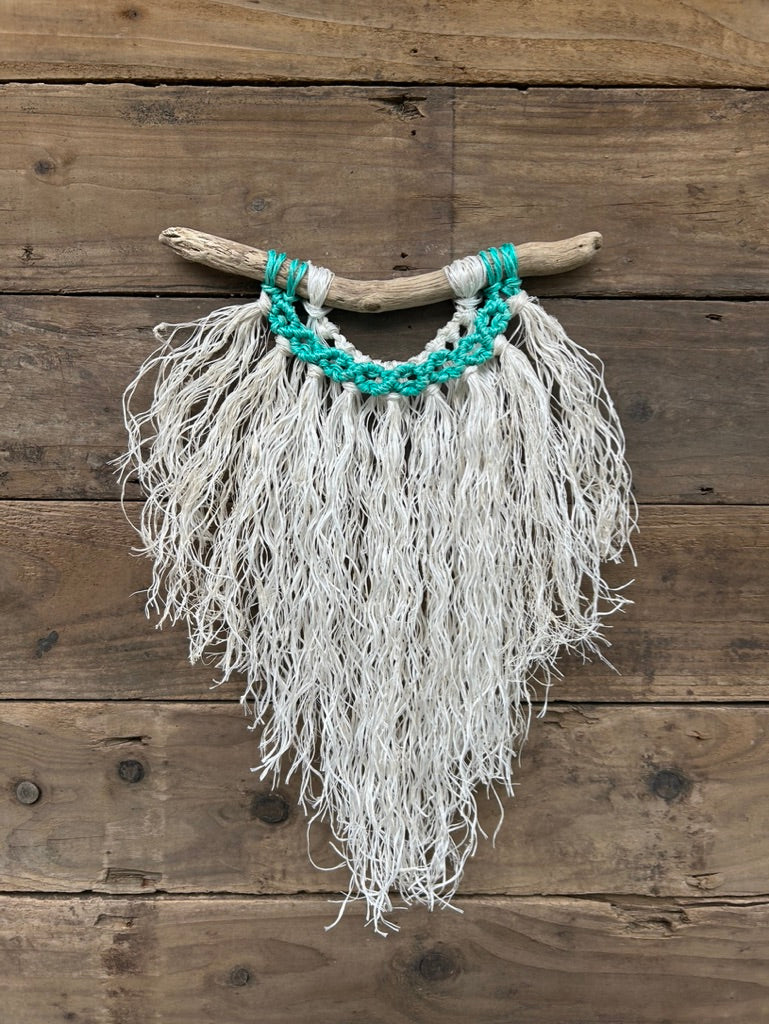 Ocean inspired wall décor handcrafted from reclaimed fishing ropes with weathered white fringe and vibrant, sea-green cirlces on driftwood