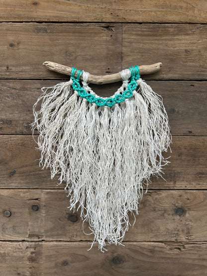 Ocean inspired wall décor handcrafted from reclaimed fishing ropes with weathered white fringe and vibrant, sea-green cirlces on driftwood