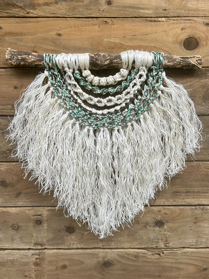 Sustainable, eco-friendly wall art created from retired fishing ropes, with a weathered white fringe and coastal tidal tones of green and black.