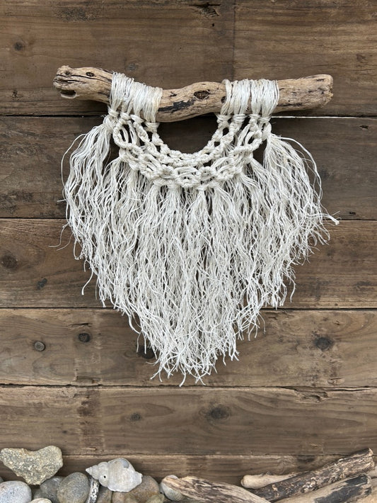 Three layered coastal boho wall art, handcrafted sustainably from recycled fishing rope, with a weathered white fringe and wave knots, set on driftwood.