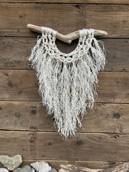 Boho inspired ocean decor, handmade from repurposed fishing rope with a soft white fringe and band of circle knots, set on driftwood.